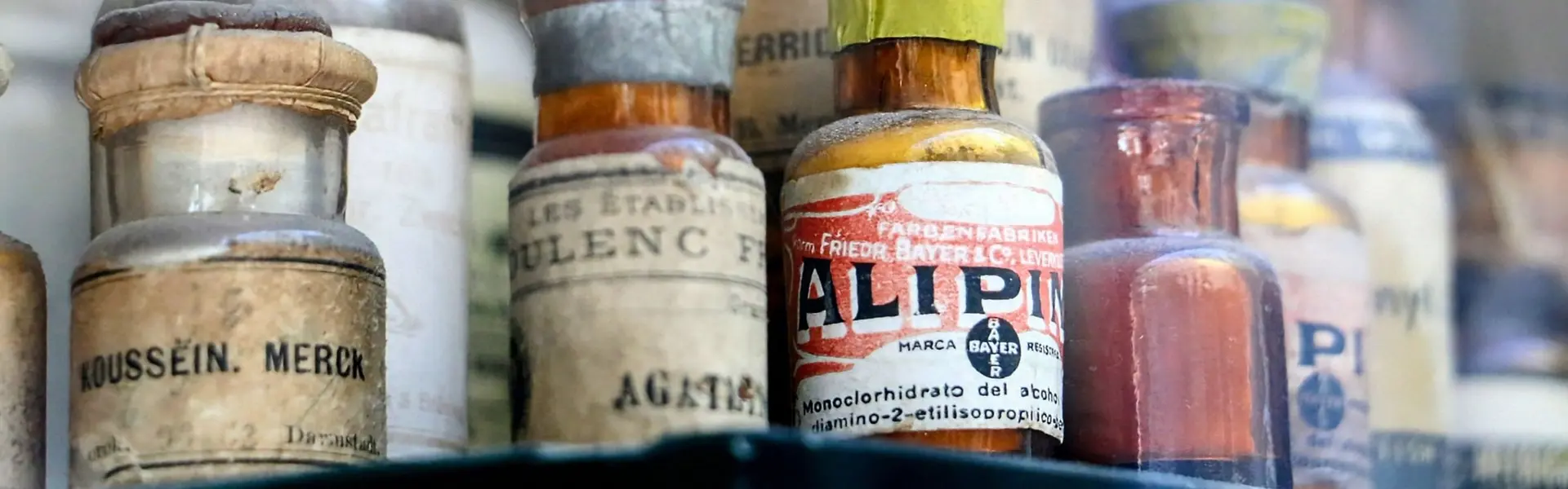 Frascos antiguos de botica con sus etiquetas originales tras el cristal de una vitrina