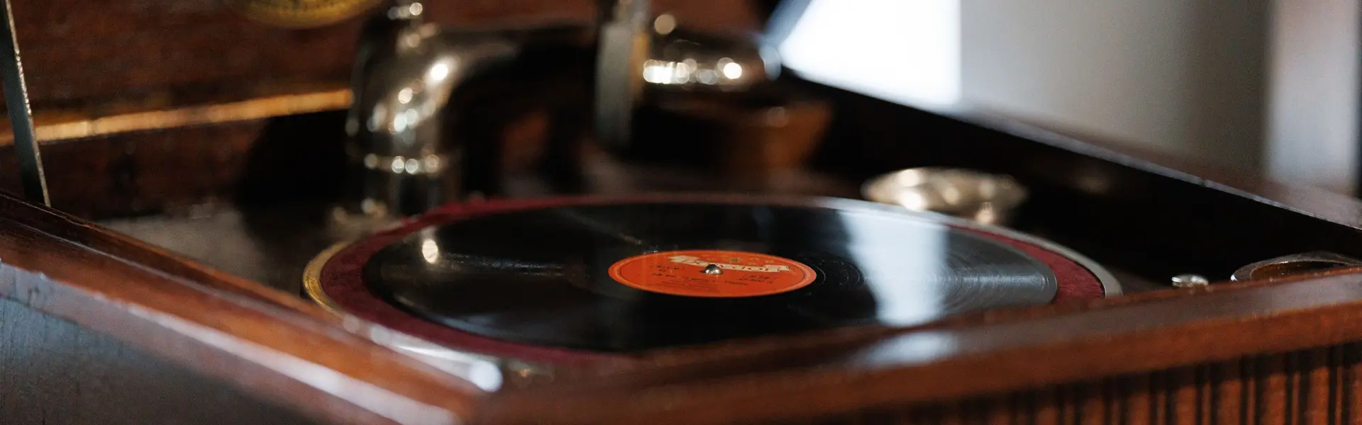 Gramófono antiguo de mueble de madera con un disco puesto en el plato
