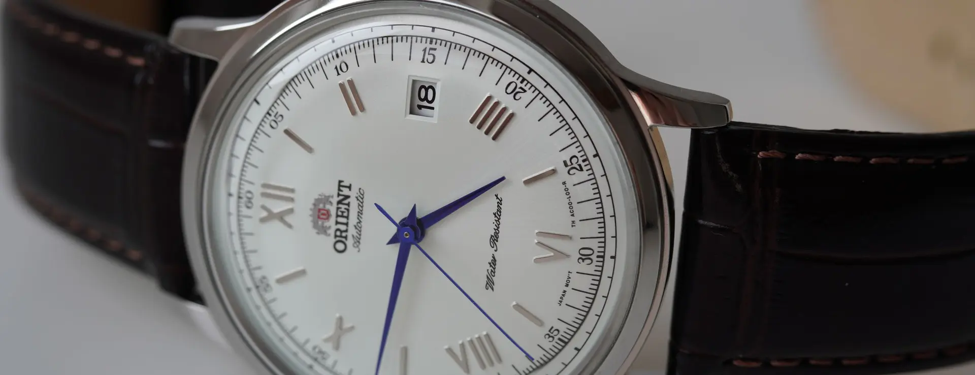Orient Bambino de esfera blanca con números romanos, agujas azuladas y correa de piel marrón