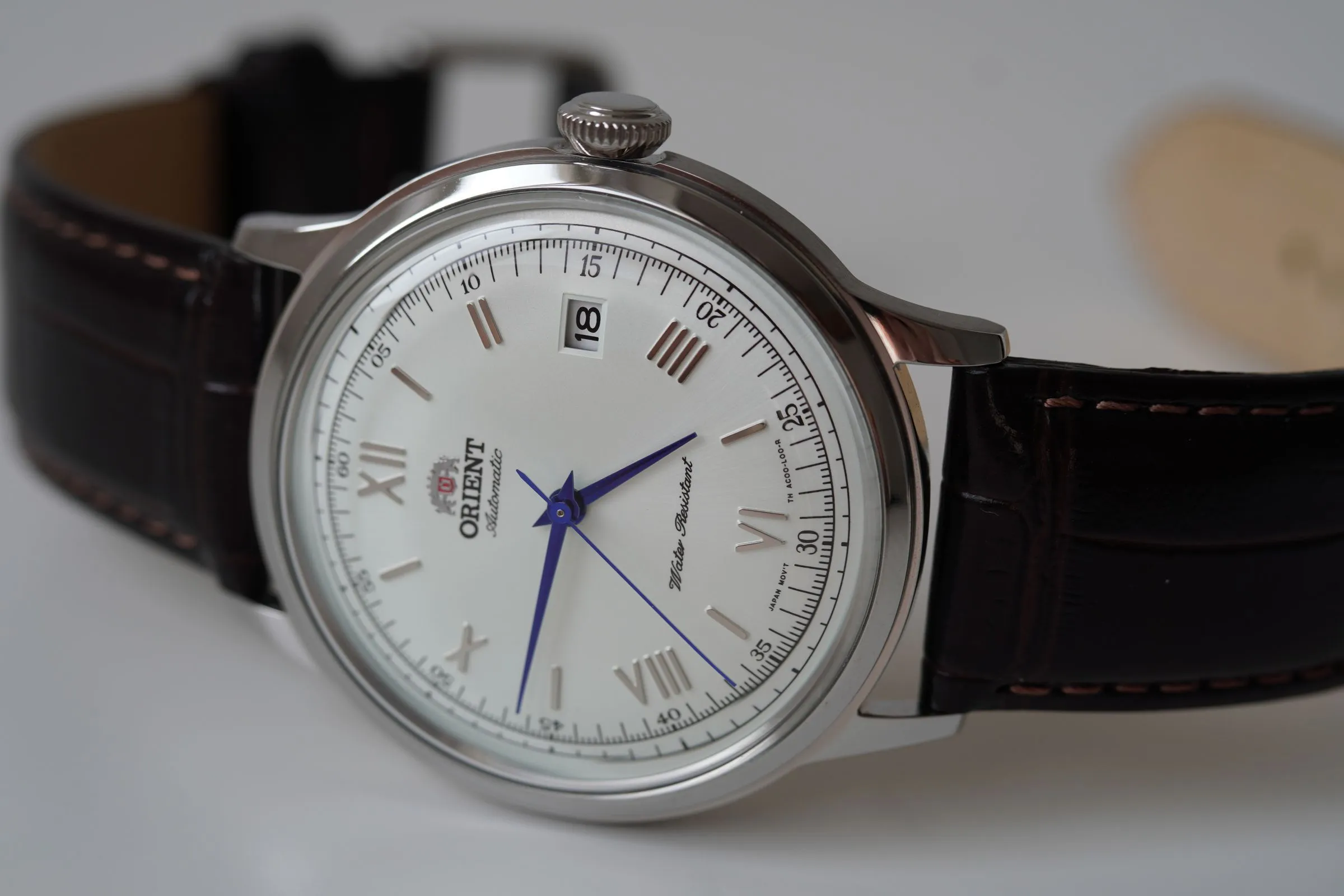 Orient Bambino de esfera blanca con números romanos y correa de piel marrón